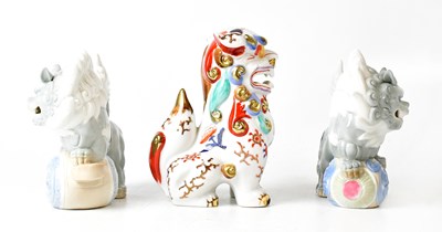 Lot 394 - YOSHIMI K; a pair of porcelain lion dogs,...