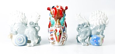 Lot 394 - YOSHIMI K; a pair of porcelain lion dogs,...