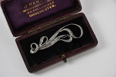 Lot 88 - A white metal diamond set brooch of scrolling...