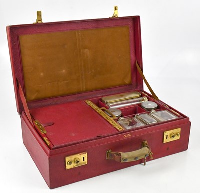 Lot 639 - CARTIER; a red pebbled leather vanity dressing...