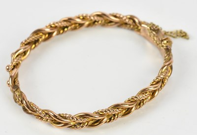 Lot 35 - A yellow metal hinged snap bangle, stamped...