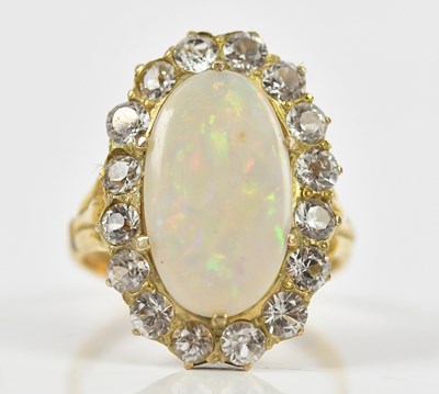 Lot 344 - A yellow metal opal set dress ring flanked,...