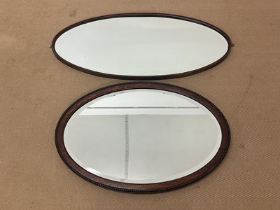 Lot 427 - An early 20th century oak oval wall mirror...