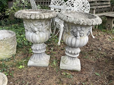Lot 1224 - A pair of reconstituted stone urns, decorated...