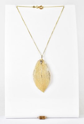 Lot 864 - A yellow metal filigree leaf pendant, length...