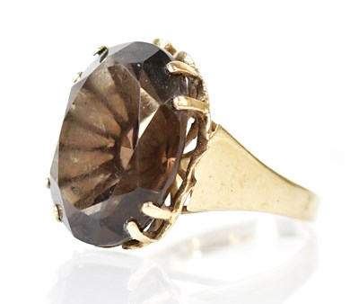 Lot 816 - A 9ct gold ring set with a large faceted smoky...