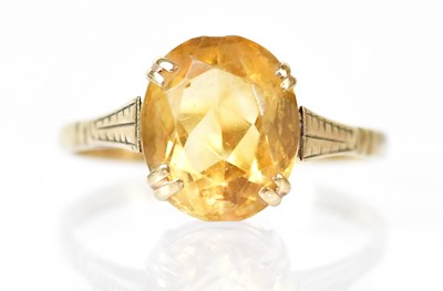 Lot 808 - A 9ct gold ring, claw set with a yellow...