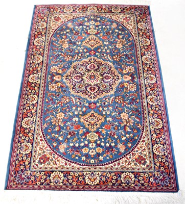 Lot 115B - A woollen blue ground carpet, with central...