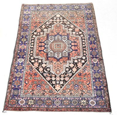 Lot 116B - A woollen hand knotted red ground carpet with...