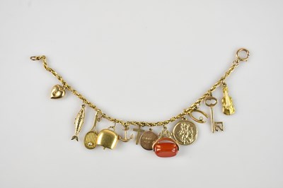 Lot 1165 - A yellow metal charm bracelet, set with eleven...