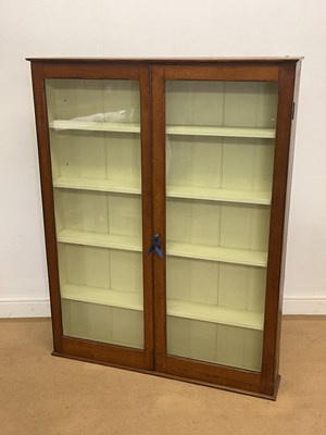 Lot 409 - An oak glazed bookcase with four shelves and...