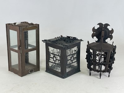 Lot 340 - Three various forged lanterns, two with glass...