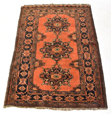 Lot 115 - A Caucasian red ground rug with floral...
