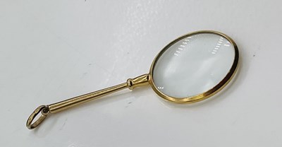 Lot 746 - A 9ct yellow gold small magnifying lens, with...