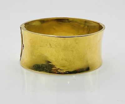 Lot 756 - An 18ct yellow gold bangle of slightly convex...