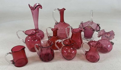 Lot 229 - Eleven cranberry glass jugs and posy vases,...