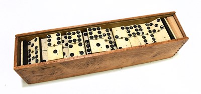 Lot 76 - A cased set of Victorian bone and ebony dominos.