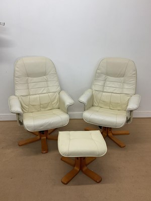 Lot 381 - A pair of cream leather swivel chairs on a...
