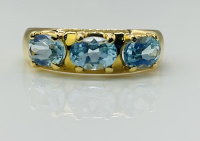 Lot 804 - An 18ct yellow gold and three stone aquamarine...