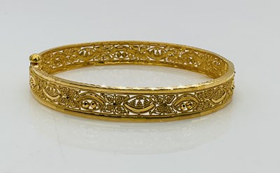 Lot 815 - A 22ct yellow gold filigree decorated bangle,...