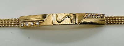 Lot 822 - An 18ct yellow gold bracelet, with central...