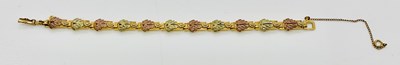 Lot 824 - A 10ct three tone leaf decorated bracelet with...