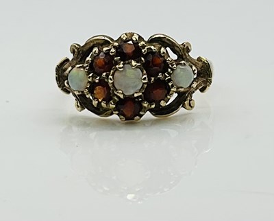 Lot 840 - A 9ct yellow gold opal and garnet dress ring,...