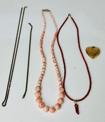 Lot 844 - A graduated string of coral coloured beads, a...