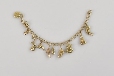 Lot 568 - A 9ct gold charm bracelet, with ten small...
