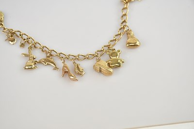 Lot 568 - A 9ct gold charm bracelet, with ten small...