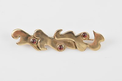 Lot 558 - A 9ct gold contemporary brooch of scrolling...