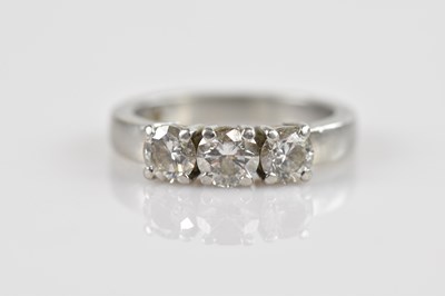 Lot 2308 - A platinum diamond set three stone dress ring,...