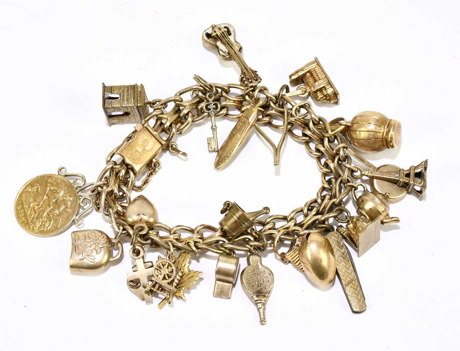 Lot 1259 A gold plated charm bracelet, housing a