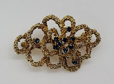 Lot 877 - A 9ct gold textured open brooch set with...