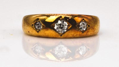 Lot 891 - An Edwardian yellow metal three stone diamond...
