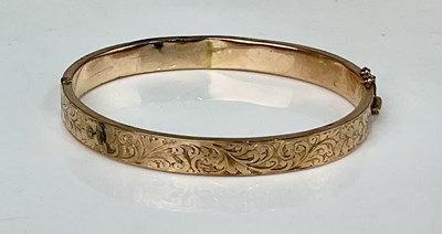 Lot 899 - A 9ct gold engraved hinged bangle, approx...