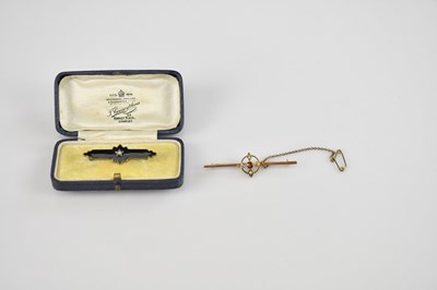 Lot 560 - A 9ct gold bar brooch, with bezel set cut ruby...