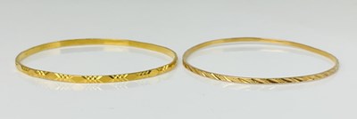 Lot 924 - Two yellow metal bangles, one with Middle...