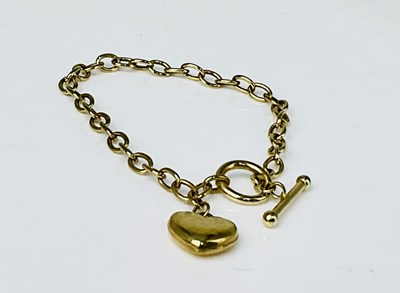 Lot 940 - A 9ct gold bracelet with heart shaped drop and...