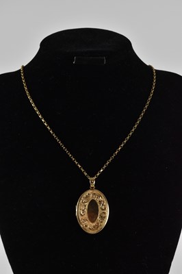 Lot 533 - A yellow metal oval locket pendant, suspended...