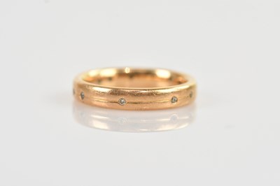 Lot 525 - An 18ct yellow gold diamond set wedding band,...