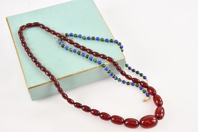 Lot 569 - A cherry amber coloured bead necklace, with a...