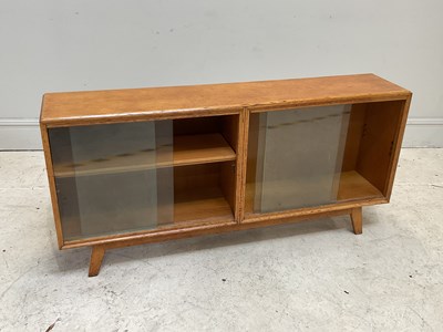 Lot 17 - A mid century oak bookcase with glazed sliding...