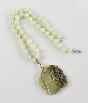 Lot 1546 - A Chinese carved soapstone pendant with yellow...