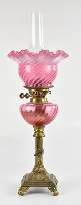Lot 2047 - A decorative brass oil lamp with cranberry...