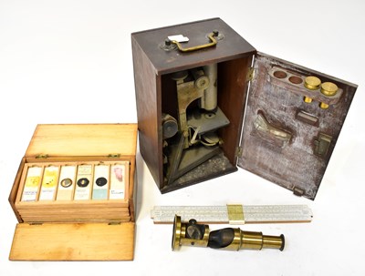Lot 647 - A brass monocular microscope with lenses, in a...