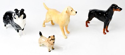 Lot 118 - BESWICK; four models of dogs, a Labrador,...