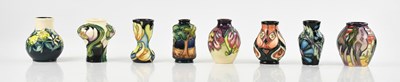 Lot 1560 - MOORCROFT; eight miniature vases, in various...