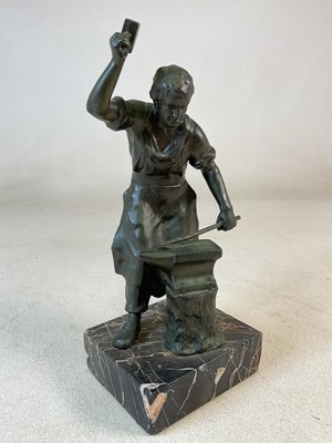 Lot 335 - A metalware statue of a blacksmith at work at...