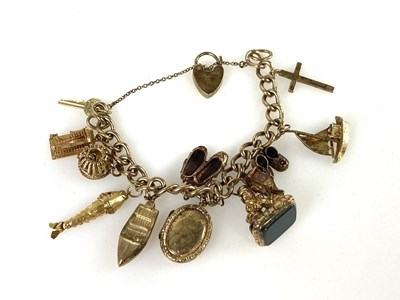 Lot 517 - A 9ct yellow gold charm bracelet, set with...